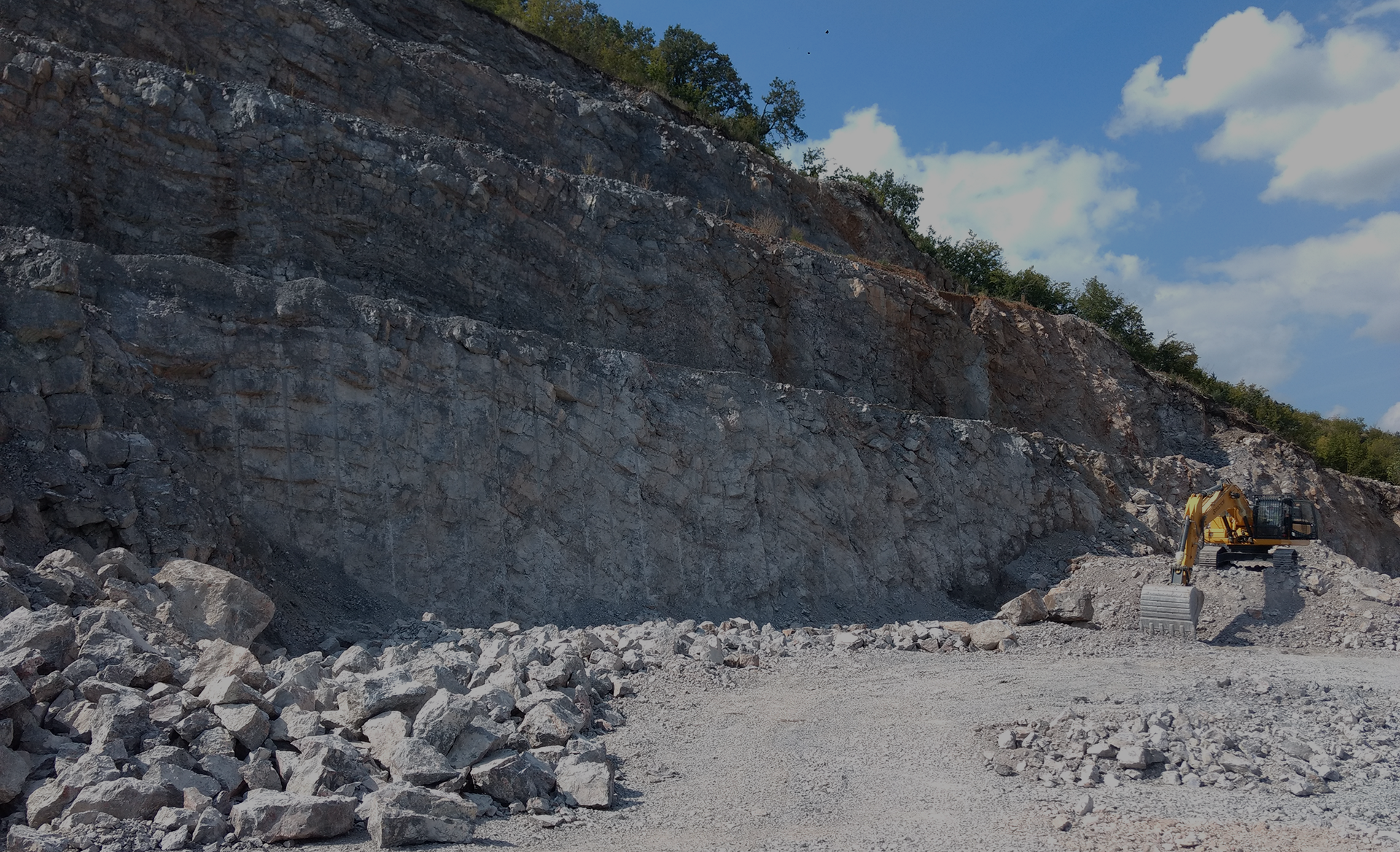 A quarry scene featuring piles of rocks and gravel, showcasing the raw materials extracted from the earth.
